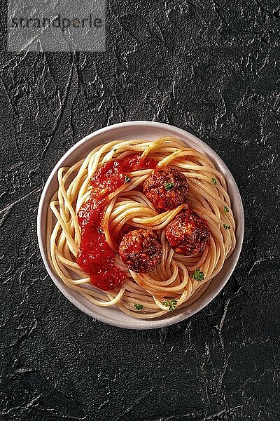 Meatballs. Beef meat balls  shot from above with spaghetti pasta  parsley  and tomato sauce  on a black background  Food photography