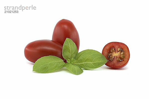 Close-up of fresh Roma tomatoes  including halved ones  alongside basil leaves on a white background. Perfect for illustrating healthy eating and fresh ingredients