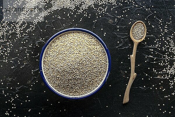 Quinoa in a bowl  healthy organic wood  uncooked  overhead flat lay shot on a black background  Food photography