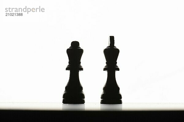 Chess pieces on a board. Backlit with a white background