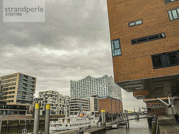 Cityscape with modern buildings on the waterfront and the Elbe Philharmonic Hall in the background on a cloudy day  Hamburg  Germany  Europe