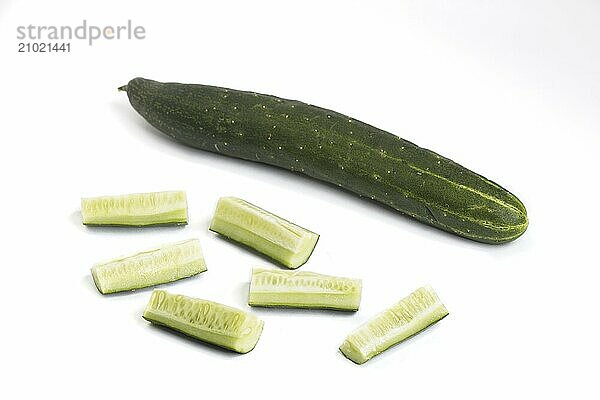 A close up photo of whole and cut up pieces of cucumber on a white background