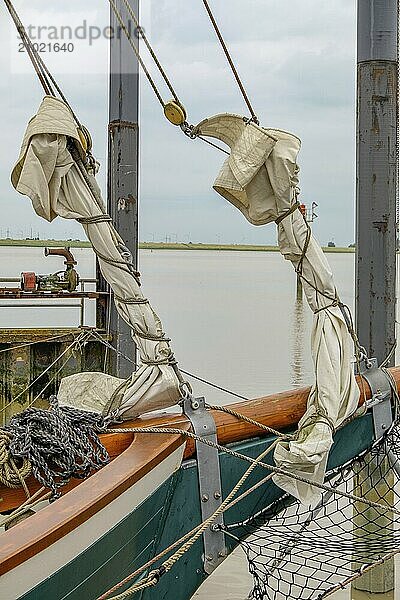 A sailing boat with furled sails and rigging on calm water  ditzum  east frisia  germany