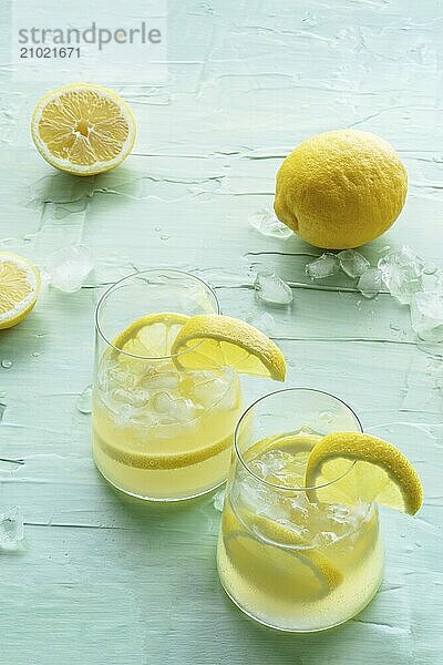 Lemonade. Lemon water drink with ice. Two glasses and fruits on a blue background. Detox beverage. Fresh homemade cocktail  Food photography  Food photography