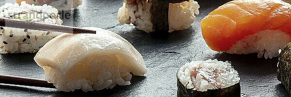 Sushi with chopsticks panorama. Whitefish nigiri on a black background  Japanese food on a plate at an Asian restaurant  Food photography