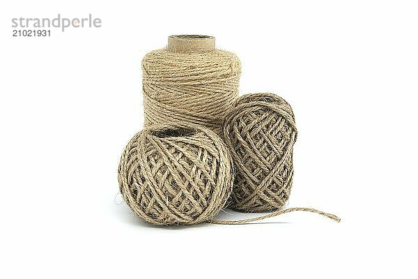 Three spools of jute twine isolated on white background  each varying in size  made from natural jute materials