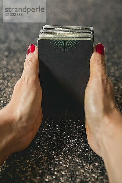 Shoulder view of a tarot reader gripping the tarot deck