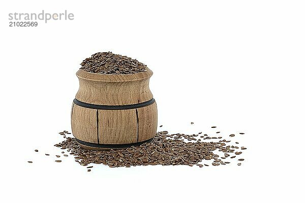 Linseed in small wooden barrel isolated on white background