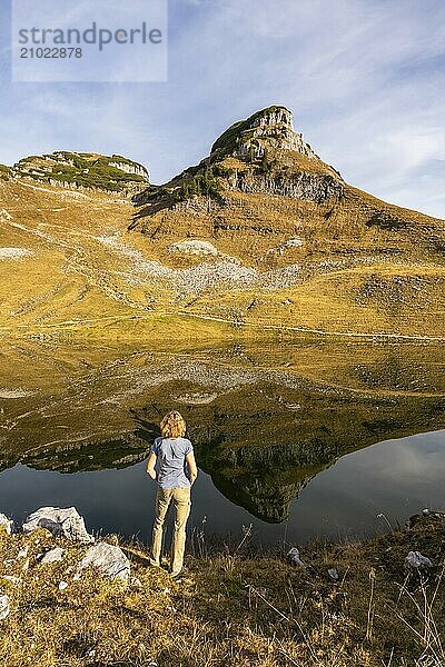 Lake Augstsee and the Atterkogel mountain on the Loser. A hiker stands on the shore. Autumn  good weather  blue sky. Reflection. Altaussee  Bad Aussee  Ausseer Land  Totes Gebirge  Styria  Upper Austria  Austria  Europe