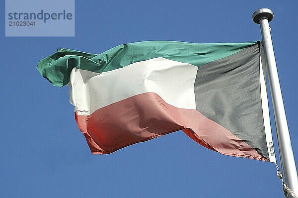 The flag of Kuwait against blue sky