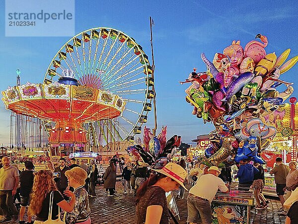 Lots of people at the Cranger Kirmes in front of the Wellenflug and the Ferris wheel  Herne  Ruhr area  North Rhine-Westphalia  Germany  Europe