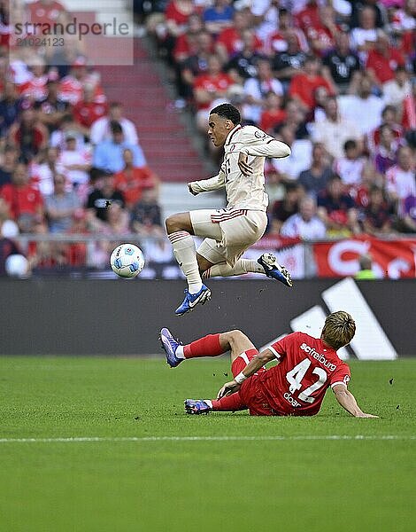 Tackle  action Ritsu Doan SC Freiburg SCF (42) against Jamal Musiala FC Bayern Munich FCB (42) Allianz Arena  Munich  Bavaria  Germany  Europe