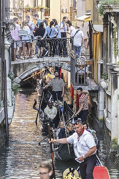 Venetian gondola with gondolier travelling on the canals  Overtourism  Venice  Venice  Italy  Europe