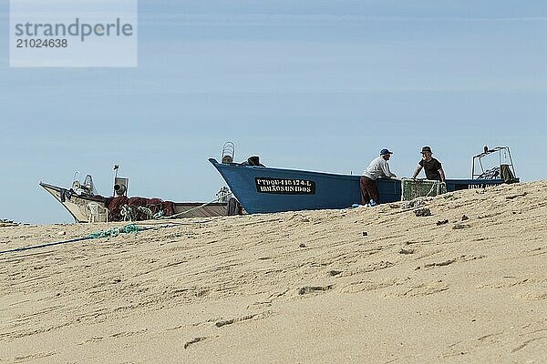 Fishermen at work on their fishing boats on the sandy beach Praia de Mar e Sol  Arcozelo  Vila Nova de Gaia  Portugal  Porto district  Portugal  Europe