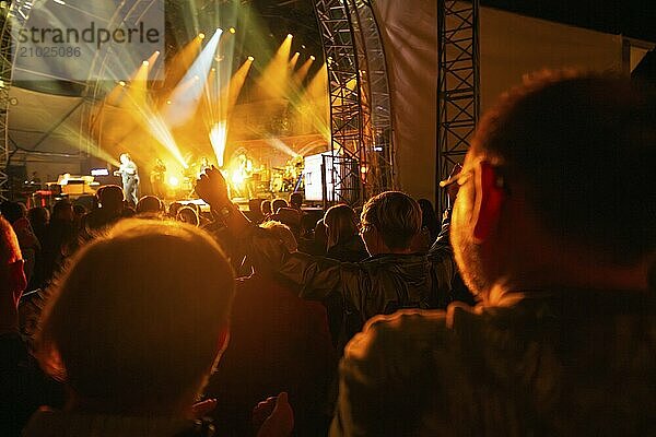 People in a crowd raise their hands while enjoying a lively concert  Klostersommer  Calw Hirsau  Black Forest  Germany  Europe