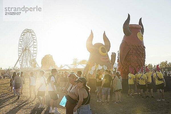 Ferris wheel and Highfield mascot Highviech in front of the evening sun at the Highfield Festival on Friday  Störmthaler See  16.08.2024