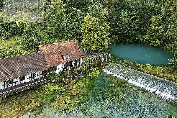 Blautopf Blaubeuren with industrial monument Hammerschmiede  source of the little river Blau in a landscape with forest. Karst spring  geotope and geopoint of the UNESCO Swabian Alb Geopark  tourist attraction. The popular excursion destination is now being thoroughly renovated and will therefore be closed to visitors until the end of 2028. Drone photo. Blaubeuren  Baden-Württemberg  Germany  Europe