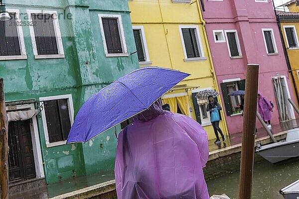 City view of Burano with colourfully painted houses and canals. Rainy weather  people are carrying umbrellas. Burano  Venice  Venezia  Italy  Europe