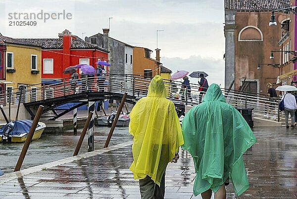 City view of Burano with colourfully painted houses and canals. Rainy weather  people are carrying umbrellas. Burano  Venice  Venezia  Italy  Europe