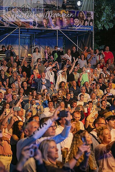 Crowd at night concert in front of stage with welcome banner  Klostersommer  Calw Hirsau  Black Forest  Germany  Europe