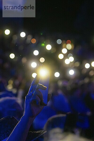 Crowd with raised hands and glowing smartphones at night at a concert or celebration  Klostersommer  Calw Hirsau  Black Forest  Germany  Europe