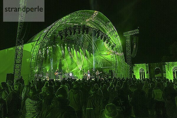 Large crowd at a night-time concert in front of a green-lit stage  Klostersommer  Calw Hirsau  Black Forest  Germany  Europe