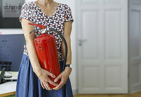 Occupational safety topic. A woman wears a fire extinguisher in an office in Berlin  09/08/2024