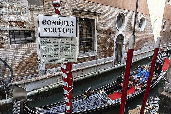 Venetian gondola with gondolier travelling on the canals of Venice  Venice  Italy  Europe