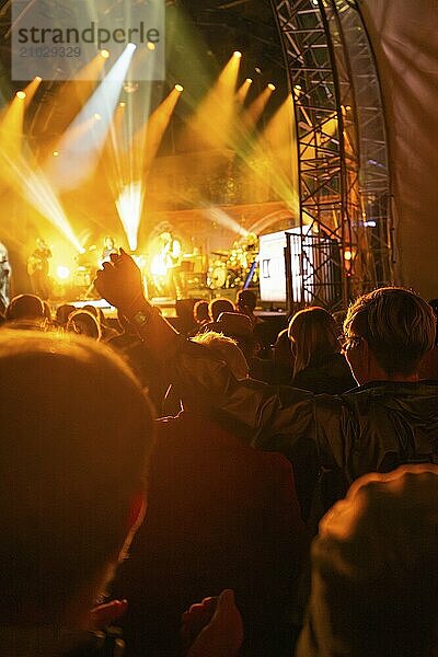 Crowds enjoy a concert under intense lighting while musicians play on stage  Klostersommer  Calw Hirsau  Black Forest  Germany  Europe