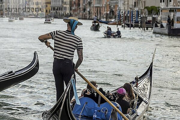 Venetian gondola with gondolier travelling on the Grand Canal. Venice  Venice  Italy  Europe