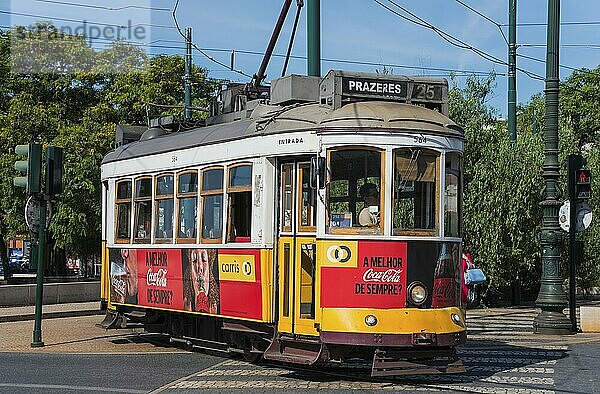 Yellow and red tram with advertising runs on rails in daylight  tram  Carros eléctricos de Lisboa  Eléctricos de Lisboa  Lisbon  Portugal  Europe