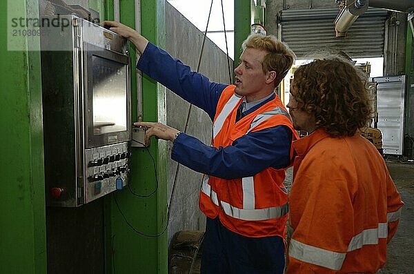 Greymouth  New Zealand  circa 2014  Two electricians examine a switchboard in a large factory preparing meat meal from offal  Oceania