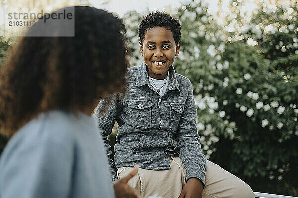 Smiling boy talking with sister in back yard