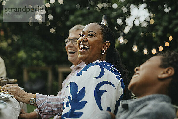 Cheerful woman having fun with male family members at social gathering