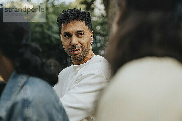 Mature man talking with female family member during garden party