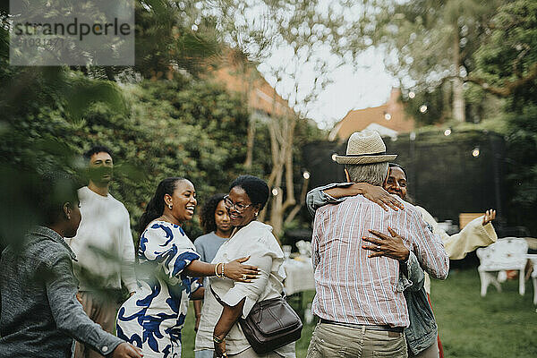 Happy family members greeting each other at garden party