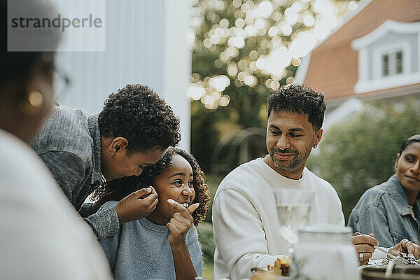 Playful children with family members during social gathering at garden party