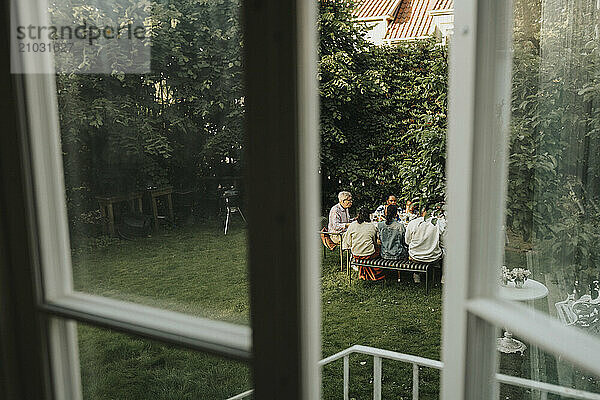 High angle view of male and female family members having dinner in back yard