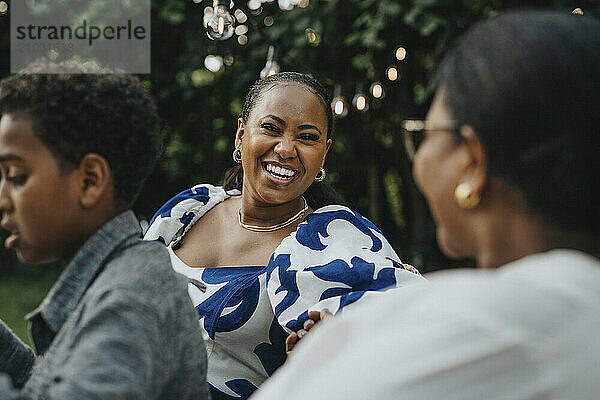 Cheerful woman enjoying leisure time with female family member during social gathering