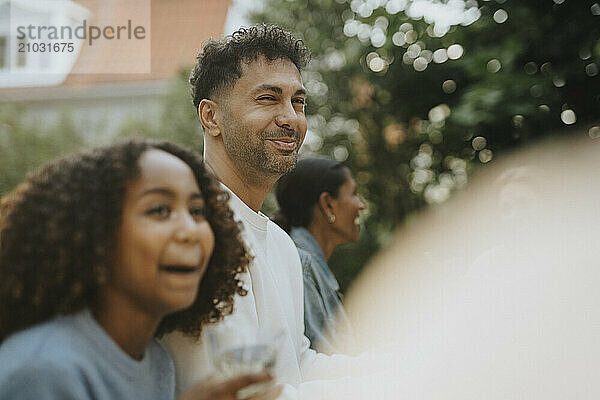 Portrait of smiling mature man with female family members at garden party