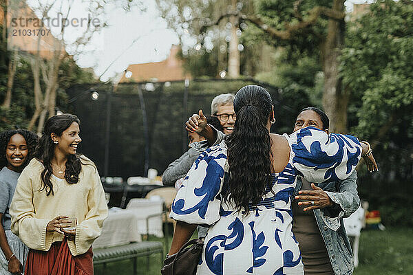 Family members greeting each other during social gathering in back yard