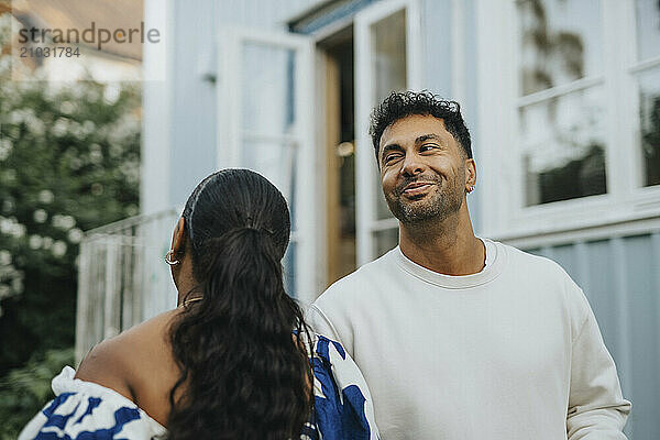 Smiling mature man dancing with female family member in back yard