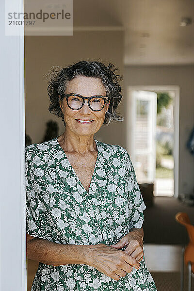 Portrait of smiling elderly woman with eyeglasses at home