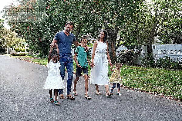 Parents with children (18-22 months  6-7  8-9) walking on street