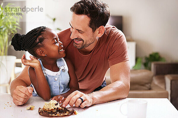 Father embracing smiling daughter (6-7) at home