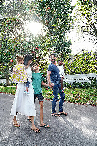 Parents with children (18-22 months  6-7  8-9) walking on street