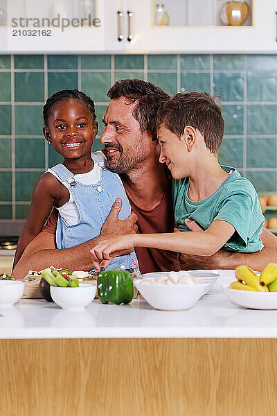 Father embracing children (6-7  8-9) in kitchen