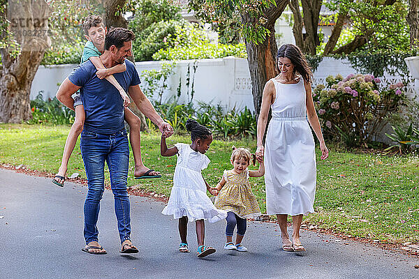 Parents with children (18-22 months  6-7  8-9) walking on street