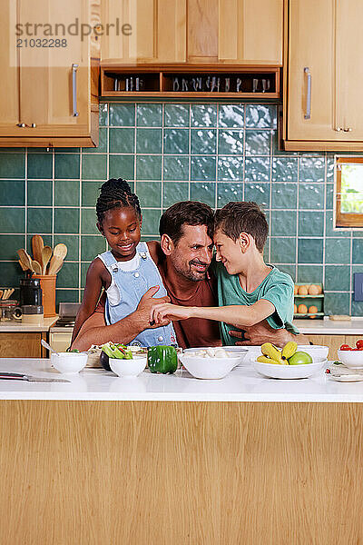 Father embracing children (6-7  8-9) in kitchen