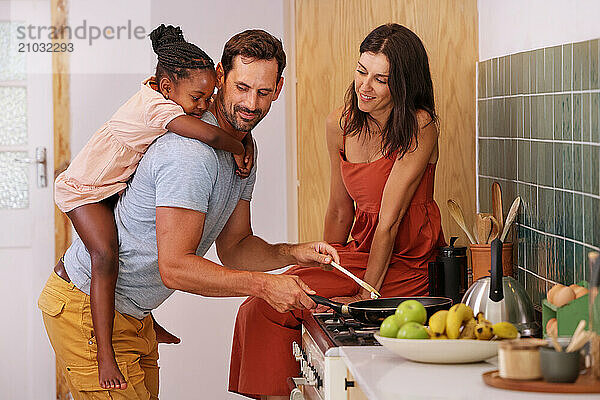 Parents with daughter (6-7) coking in kitchen